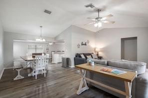 Relax in this stylish living space with a dining area, sofa, and kitchen, perfect for unwinding.