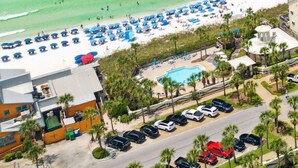 A beach resort with a pool, beach umbrellas, and a parking area. - 🐚 Silver Beach Retreat | Beachfront | FREE VIP Package | Beach Chair Service (Destin)