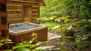 Eine Holzdiele mit Whirlpool und üppigem Garten.