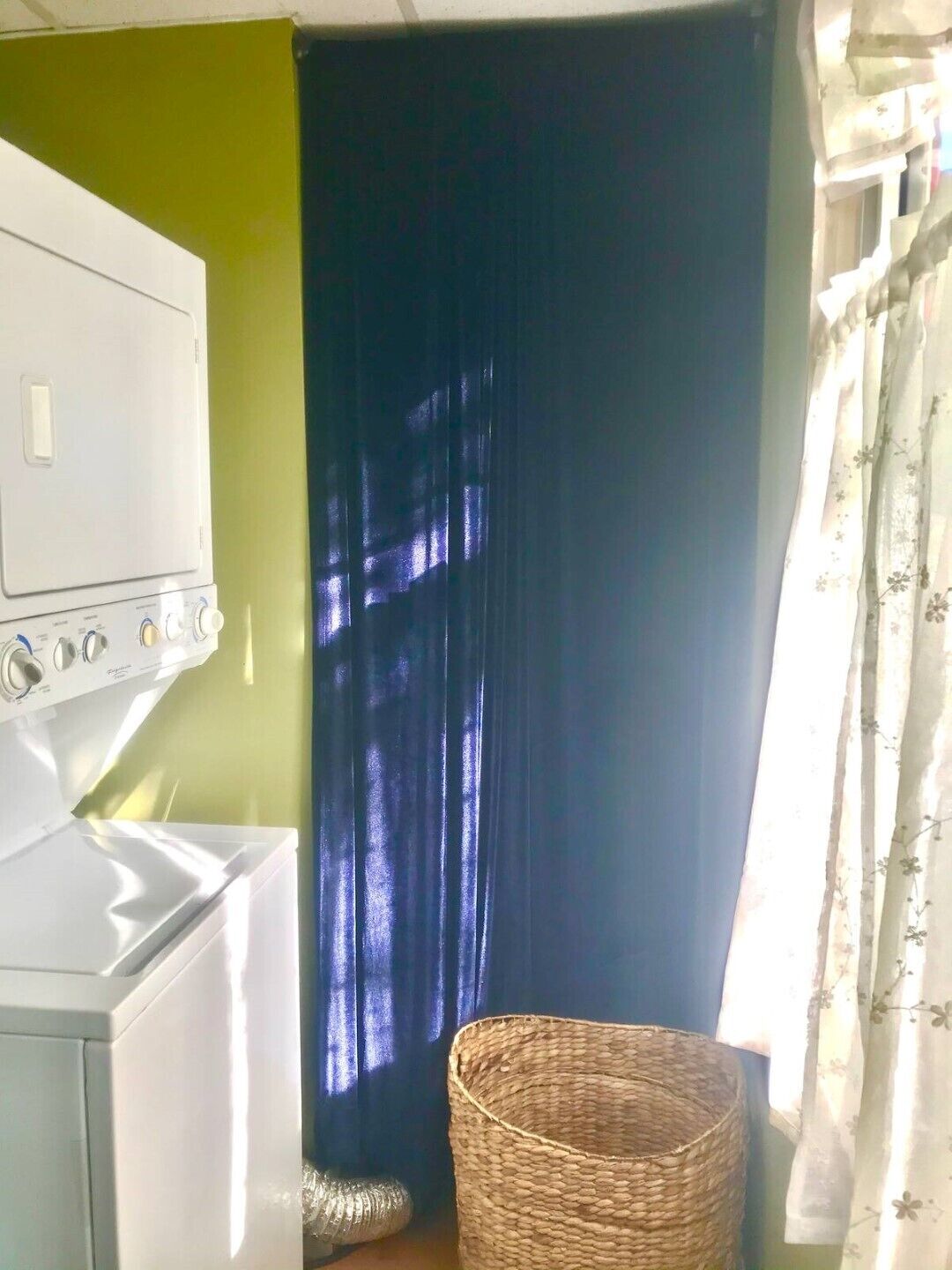 A compact laundry area with a washing machine and a drying rack.