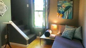 Een moderne woonkamer met een bank, een tafel, een lamp en een trap.