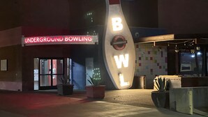An entrance to an underground bowling alley with a neon sign and a large bowling pin sculpture. - ♥ Charming entire house in the heart of Lancaster ♥ (Lancaster)