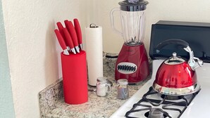 A compact kitchen with a gas stove, a red kettle, a blender, and a drawer with red oven mitts. - ♥ Charming entire house in the heart of Lancaster ♥ (Lancaster)