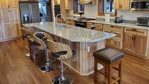 A modern kitchen with wooden cabinets, stainless steel appliances, and a granite countertop. - Winter celebration and solitude at Whispering Willows Farm (Dushore)