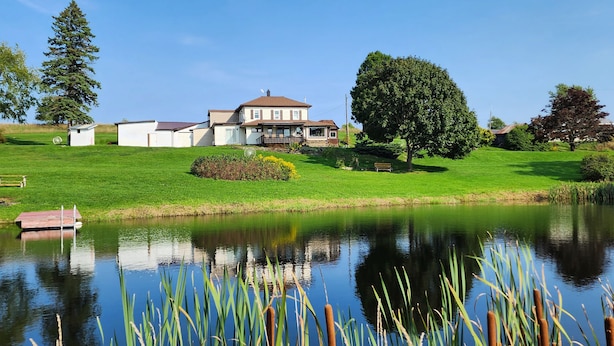 A house with a large lawn, a pond, and a dock. - Winter celebration and solitude at Whispering Willows Farm (Dushore)