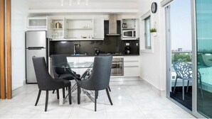 Una cucina moderna con tavolo e sedie in vetro, forno integrato e microonde.