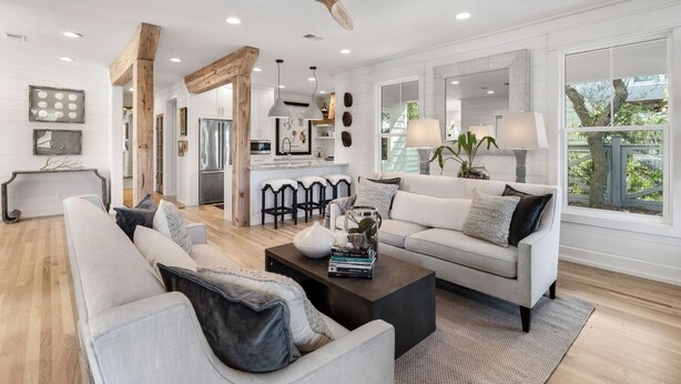 A spacious living room with a large sofa, a coffee table, and a dining area with a kitchen in the background. - 30A Home in Seacrest - PRIVATE POOL - Peak-A-Boo Ocean View 2 min Walk to Beach (Seacrest)