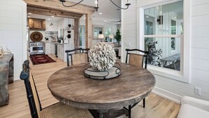 A dining area with a round wooden table, chairs, and a unique centerpiece. - 30A Home in Seacrest - PRIVATE POOL - Peak-A-Boo Ocean View 2 min Walk to Beach (Seacrest)