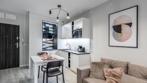 A modern apartment with a dining area, kitchenette, and a living room with a sofa. - Holiday Mountain Residence by Interhome (Swieradow Zdroj)