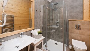 A modern bathroom with a glass-enclosed shower, a wooden vanity, and a white toilet. - Lipki Park Resort by Interhome (Zakopane)