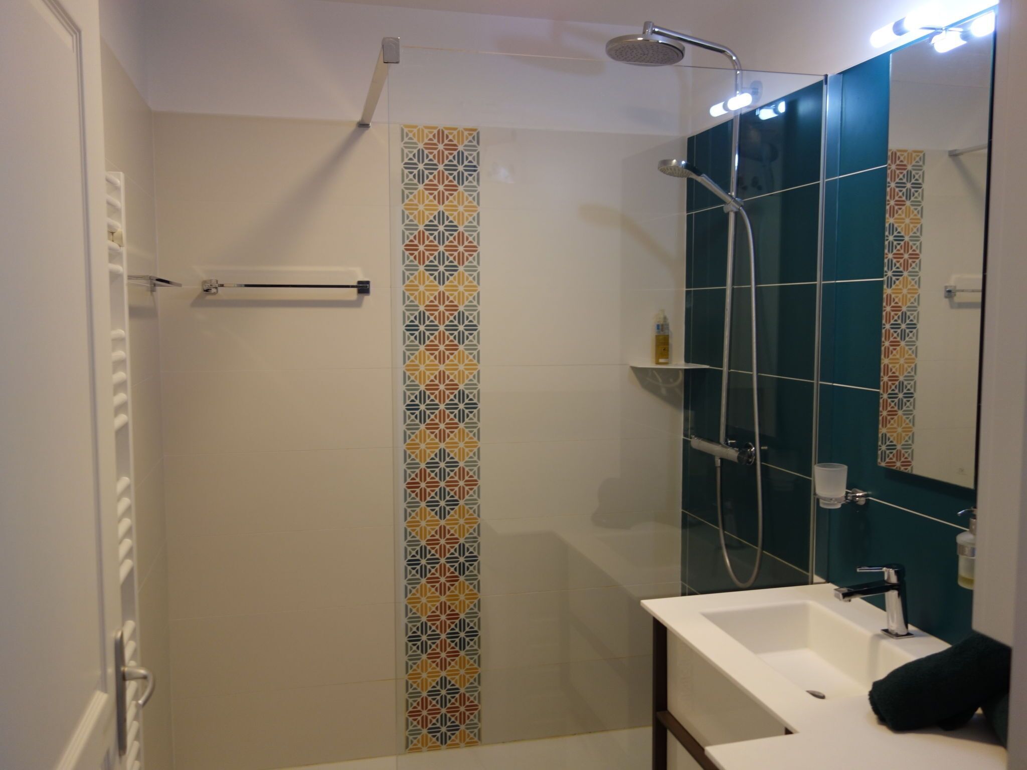 Ein Badezimmer mit Dusche, Waschbecken und Spiegel.
