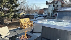 An outdoor hot tub area with a fire feature and seating. - 63 Bar (Red Lodge)