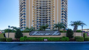 A tall hotel building with a sign reading "Maisons-sur-Mer" and a street sign indicating a weight limit of 20,000 lbs. - Elegant Oceanfront 2 Bedroom 2 Bath Ocean View Condo at Maisons-Sur-Mer in Myrtle Beach (Myrtle Beach)