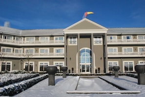 A multi-story hotel with a symmetrical facade, large windows, and a central entrance.