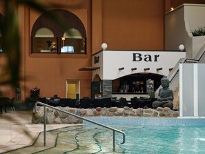 An indoor bar area with a pool, stone wall, and Buddha statue. - Hotelzimmer - Van der Valk Resort Linstow Hotel (Dobbin-Linstow)