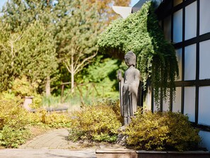 Una estatua en un jardín con un sendero y follaje.