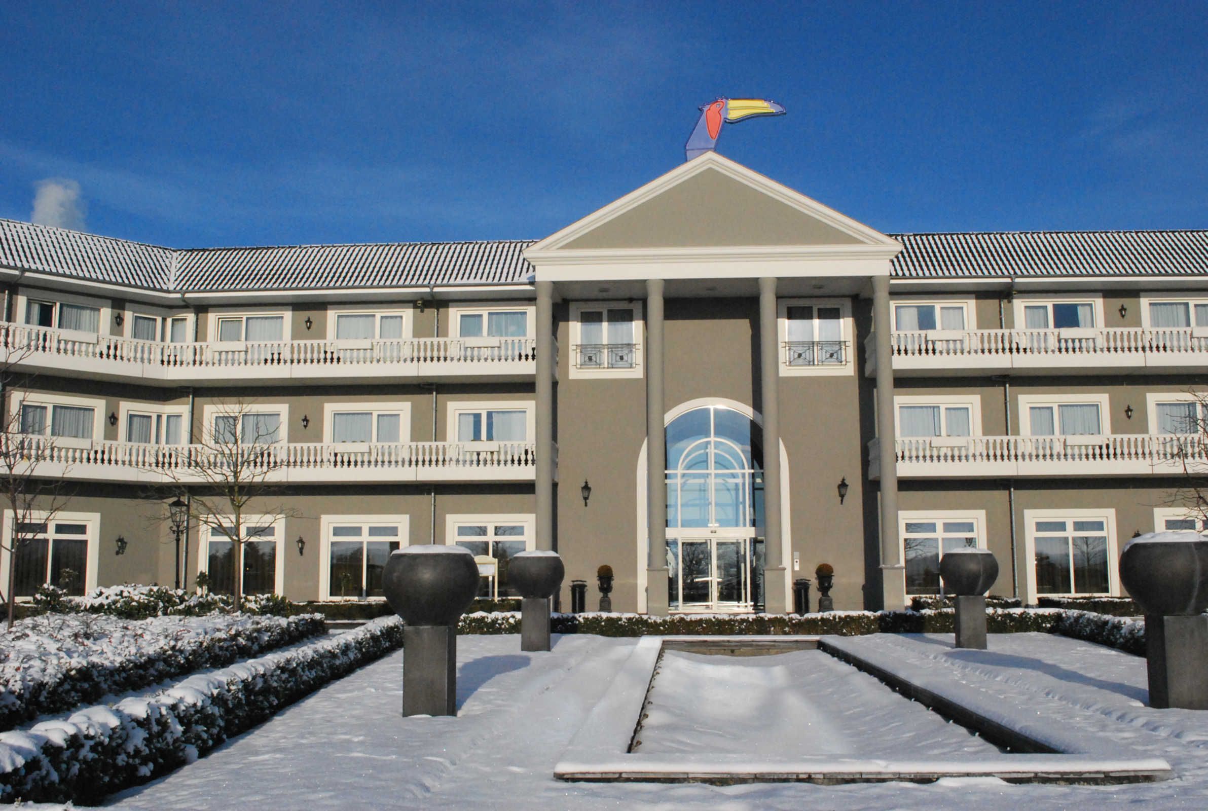 A multi-story hotel with a symmetrical facade, large windows, and a central entrance.