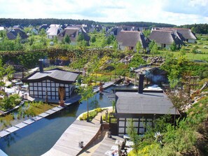 A riverside property with traditional architecture, a dock, and a small garden.