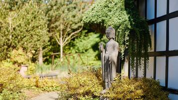 A statue in a garden with a pathway and greenery.