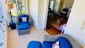 A room with wicker furniture, a blue accent wall, and a view of the outdoors. - Classic Beach Cottage In Town (Rehoboth Beach)