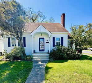 A single-story house with a front porch, a chimney, and a number '301' on the side. - Classic Beach Cottage In Town (Rehoboth Beach)