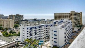 Un hotel de varios pisos con balcones, piscina y vista al mar.