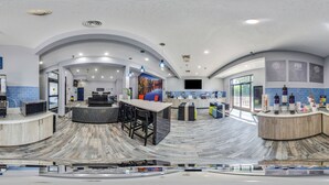 A modern kitchen with a curved island, bar seating, and a view of the outdoors.