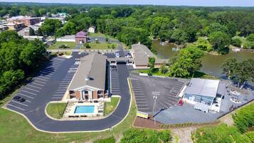 Guests can park their vehicles in the well-organized lot, with a pool and lush surroundings nearby.