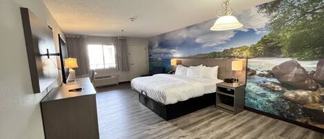 A hotel room with a bed, bedside lamps, a desk, a chair, a large window with curtains, and a mural of a river scene.