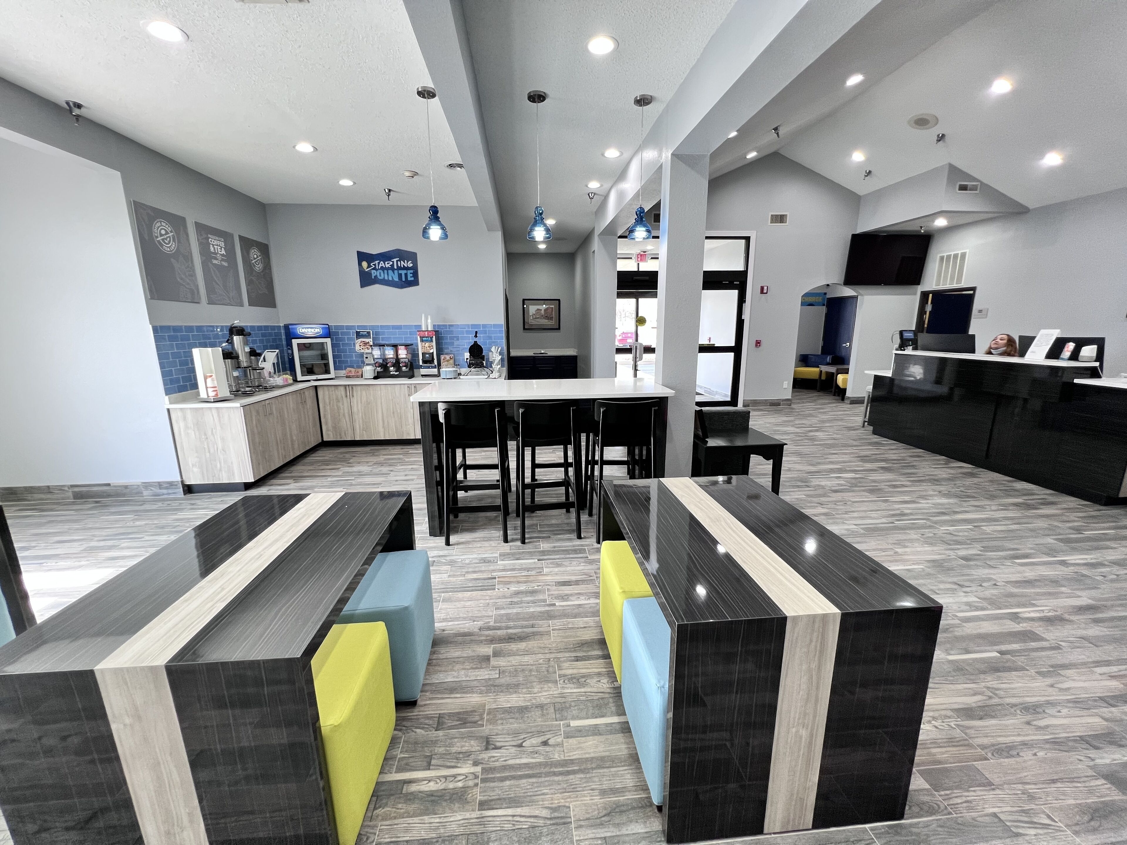 Un área de recepción moderna con mostrador, asientos y una estación de café.
