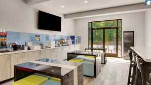 A modern kitchen with a large island, bar stools, and a view of the outdoors.