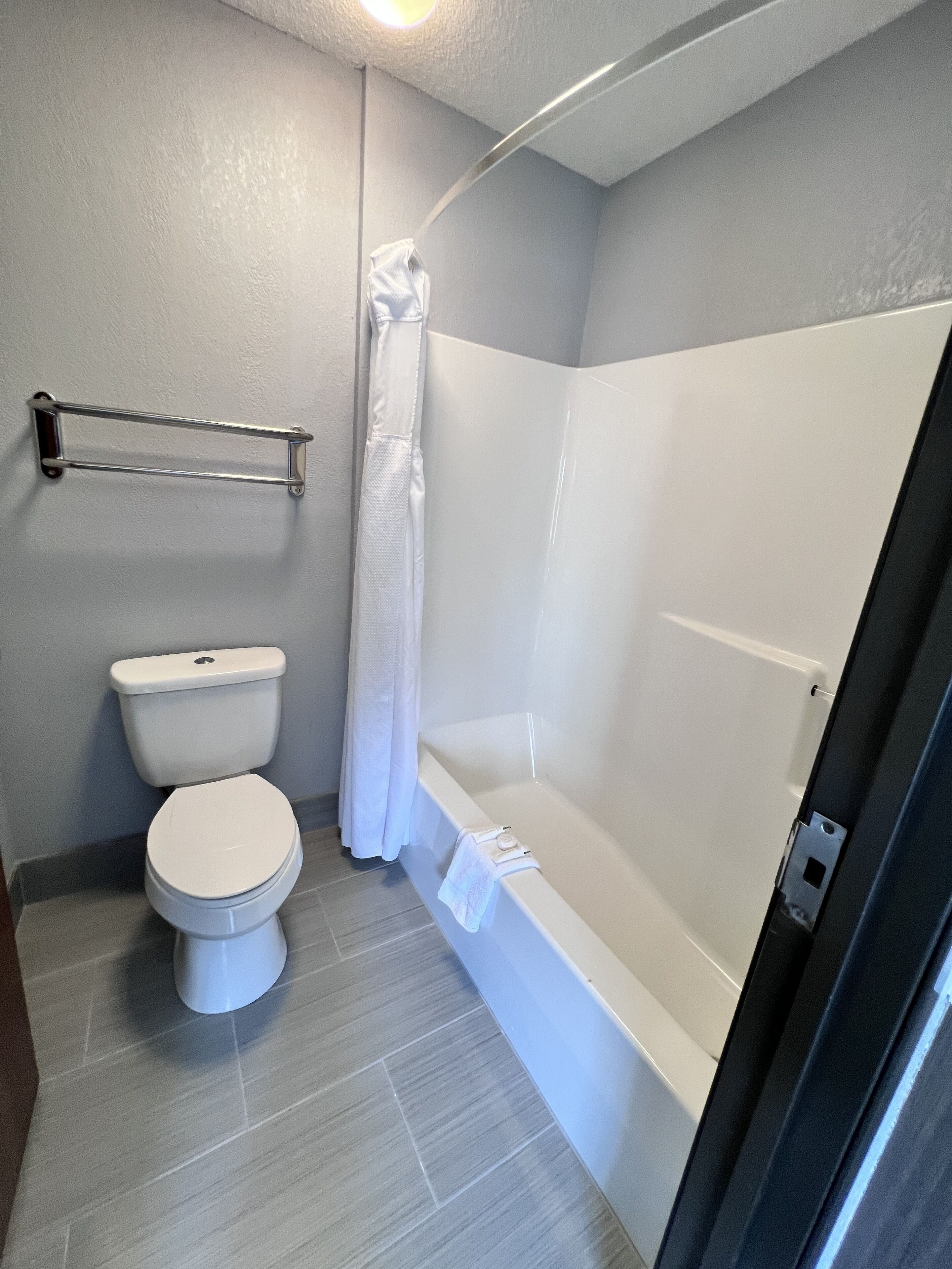 Egy fürdőszoba, amelyben WC, fürdőkád és zuhanyzó található.