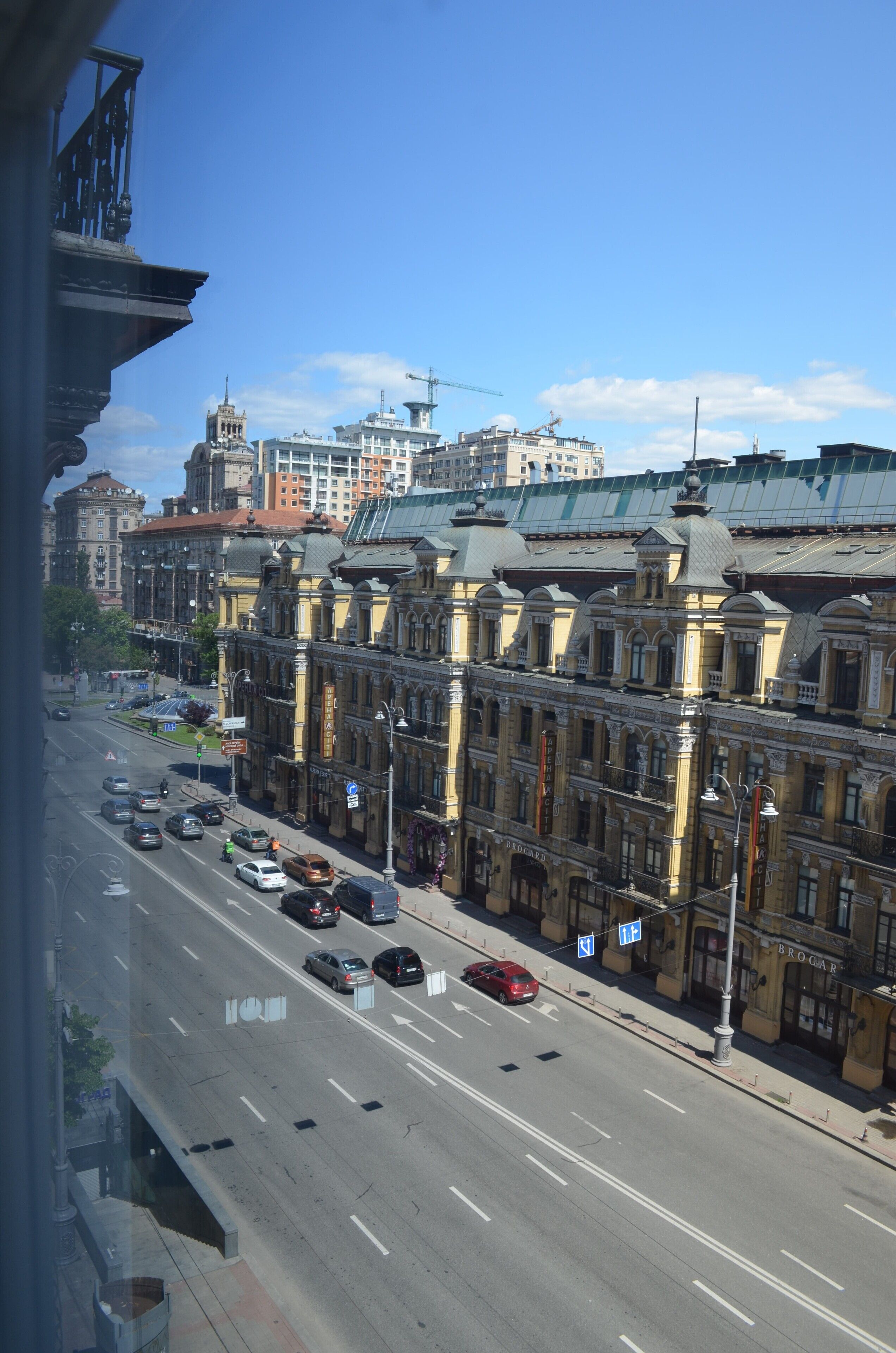 A street view with historic buildings, a clear sky, and a busy road with cars.