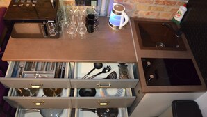 A kitchen with a countertop, a sink, and a drawer organizer with utensils. - Arena and Kreshatik, best location, VIP Studio  (Київ)