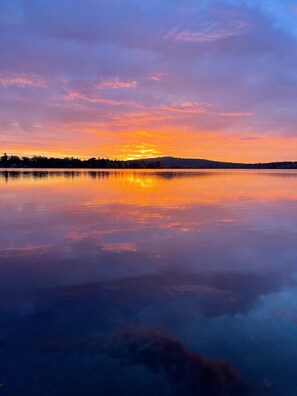 A calm lake at sunset with a clear reflection of the sky. - Hermon Pond Studio (Hermon)