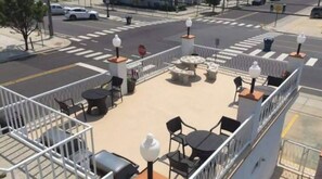 Una terrazza sul tetto con posti a sedere e tavoli all'aperto, un segnale di stop e un attraversamento pedonale.