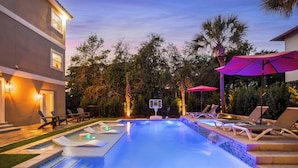 A swimming pool with a basketball hoop, lounge chairs, and umbrellas. - Destiny West, Huge Pool/Spa, Game Room, Gulf Views, Theater, Golf Cart Rental (Destin)