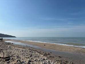 Ein Strand mit felsigem Gelände und blauem Himmel.