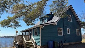 A house with a porch, a staircase, and a view of a body of water.