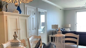 A dining area with a wooden table, chairs, and decorative items including a fish sculpture and lanterns.
