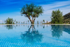 A clear pool with a tree in the center, surrounded by greenery and a clear sky. - Villa Aqua, New Luxury Villa with Seaview & Private Pool (Bali)