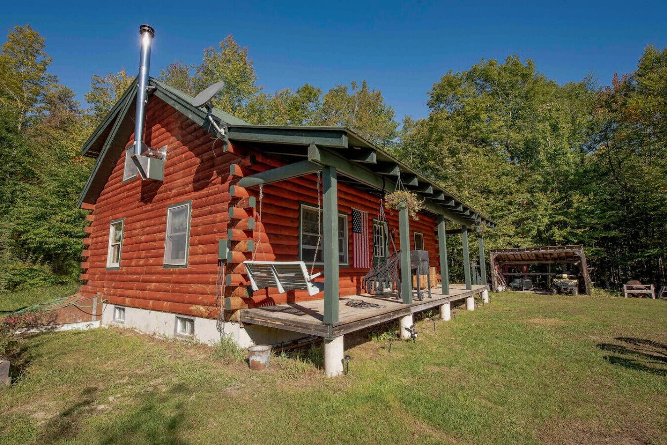 Beautiful log cabin with porch swing — your serene nature escape.