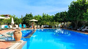 A clear blue pool surrounded by lounge chairs and umbrellas, with trees in the background. - hotel villa fernanda  (Massa Lubrense)