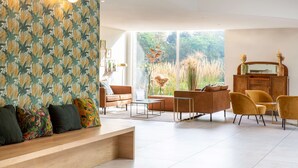 A modern living room with a sofa, chairs, a coffee table, and a cabinet. - Best Western Hotel du Lac Dunkerque (Armbouts-Cappel)