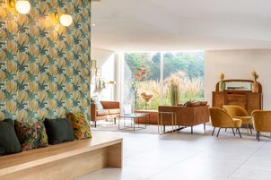 Una sala de estar moderna con un sofá, sillas, una mesa de centro y un mueble aparador.