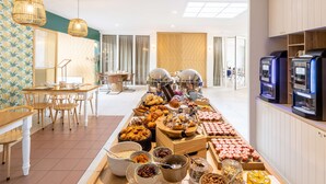 A buffet area with various food options, a seating area with tables and chairs, and a kitchen area with appliances. - Best Western Hotel du Lac Dunkerque (Armbouts-Cappel)