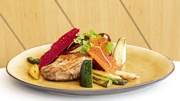Ein Teller mit gegrilltem Fleisch, Gemüse und einer dekorativen Scheibe Rote Bete.