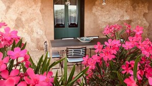 A rustic dining area with a table and chairs, a decorative bowl, and a door with glass panels. - Graffeo Countryside Sea View Homes in Menfi in Sicily - Casa delle Rose -  (Menfi)