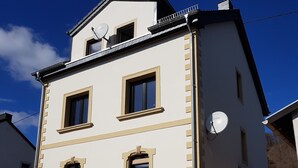 A two-story building with a symmetrical facade, multiple windows, and satellite dishes. - Ferienwohnung.-monteur/geschäftsleute (Wallerfangen)