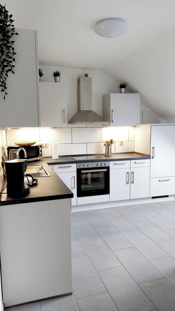 Een koelkast, een microgolfoven, een kookplaat, een vaatwasser